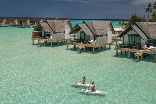 Fushifaru Maldives, Blick auf die Jacuzzi Water Villen, Stand-Up Paddle Board