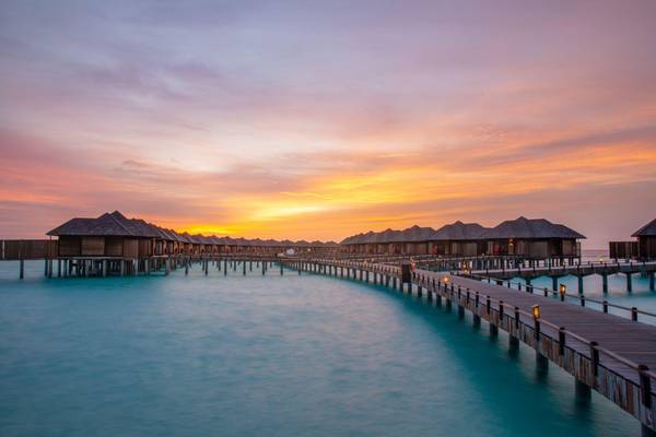 Sun Siyam Iru Fushi, Malediven, Wasservillen im Abendrot