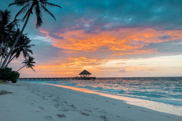 Reethi Faru Resort, Malediven, Slider, Strand und Meer bei Abendrot