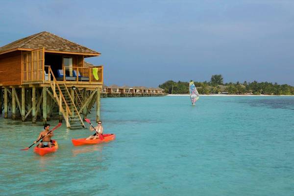 Vilamendhoo Island Resort, Malediven, Jacuzzi Water Villa, Außenansicht Wasservilla mit Paar im Kajak