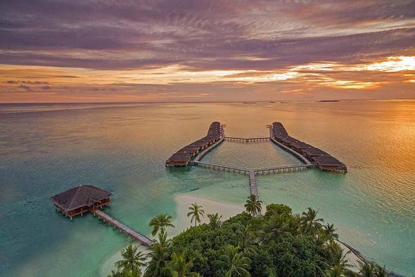 Blick auf die Wasservillen im Abendrot, Medhufushi Island Resort, Maldives
